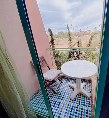 a small balcony with a table and a chair at Appartement d'orient centre ville in Oulad Akkou