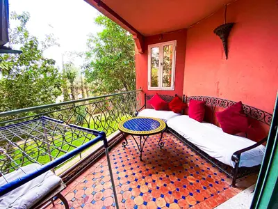 a balcony with a couch and a table on a balcony at Appartement d'orient centre ville in Oulad Akkou