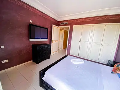 a bedroom with a bed and a flat screen tv at Appartement d'orient centre ville in Oulad Akkou