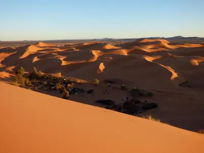 an aerial view of a desert with a group of animals at Dartagounite in Oulad Akkou