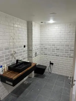 a bathroom with a black sink and white brick walls at la bella cita fes in Fès