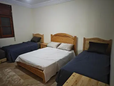 two beds in a room with blue sheets at Gite les pommiers de tizi in Beni Mellal