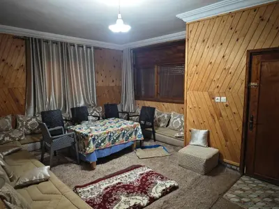 a living room with a bed and a couch and a table at Gite les pommiers de tizi in Beni Mellal