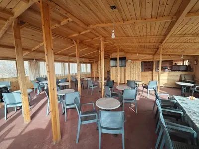 a room with tables and chairs in a building at Gite les pommiers de tizi in Beni Mellal