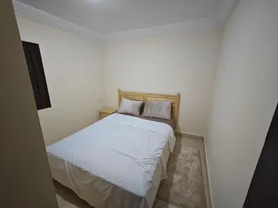 a bedroom with a bed with white sheets and pillows at Gite les pommiers de tizi in Beni Mellal