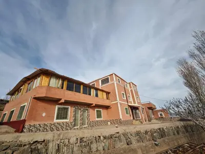 a large house on top of a stone wall at Gite les pommiers de tizi in Beni Mellal