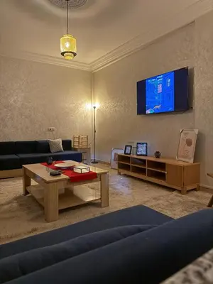 a living room with a couch and a tv on the wall at Appartement centre errachidia in Er Rachidia