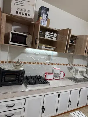 a kitchen with a stove and a microwave at Appartement centre errachidia in Er Rachidia