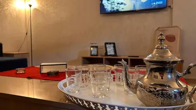 a tray of glasses on a table with a tea kettle at Appartement centre errachidia in Er Rachidia