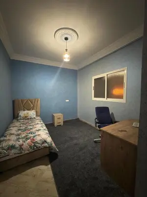 a bedroom with a bed and a desk and a chair at Appartement centre errachidia in Er Rachidia