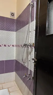 a bathroom with a shower with purple and white tiles at Appartement centre errachidia in Er Rachidia