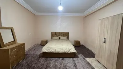 a bedroom with a bed and a dresser and a mirror at Appartement centre errachidia in Er Rachidia