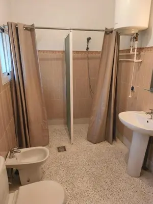 a bathroom with a shower and a toilet and a sink at maison de tourisme el amal in Oulad Akkou