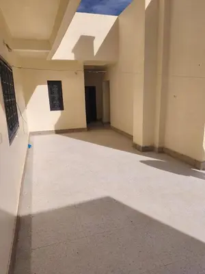 an empty hallway of a building with a shadow on the floor at maison de tourisme el amal in Oulad Akkou