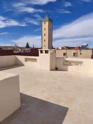 a building with a clock tower on top of it at maison de tourisme el amal in Oulad Akkou