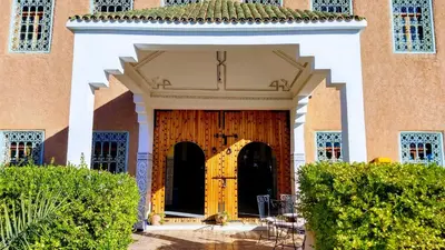 a building with a large wooden door in a yard at hotel and restaurant kasbah draa in Agdz