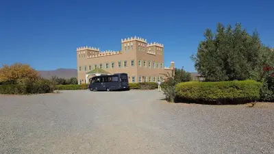 a bus parked in front of a large building at hotel and restaurant kasbah draa in Agdz