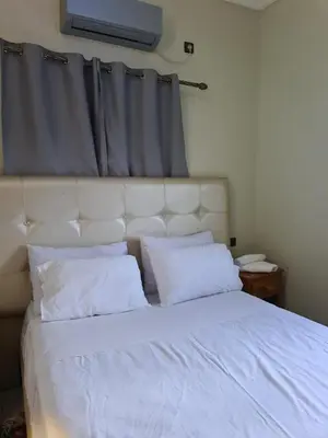 a bed with white sheets and pillows in a bedroom at hotel and restaurant kasbah draa in Agdz