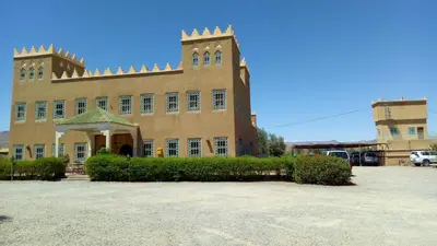 a large brick building with a tower on top of it at hotel and restaurant kasbah draa in Agdz