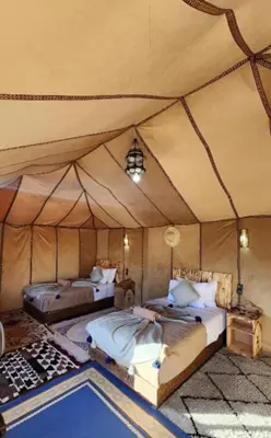 a bedroom with two beds in a tent at Merzouga Dream Starlight in Merzouga