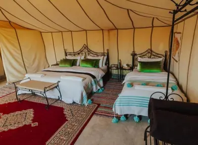 a bedroom with two beds in a tent at Merzouga Dream Starlight in Merzouga