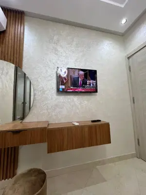 a living room with a tv on the wall at Résidence Saadia, Khouribga in Khouribga