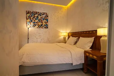 a bedroom with a bed and a painting on the wall at URBAN WHITE Elya 1 in Beni Mellal