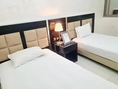 a hotel room with two beds and a table with a picture at URBAN WHITE Elya 1 in Beni Mellal