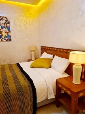a bedroom with a bed and a table with two lamps at URBAN WHITE Elya 1 in Beni Mellal