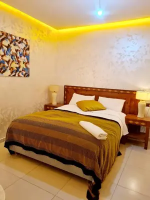 a bedroom with a bed with two pillows on it at URBAN WHITE Elya 1 in Beni Mellal