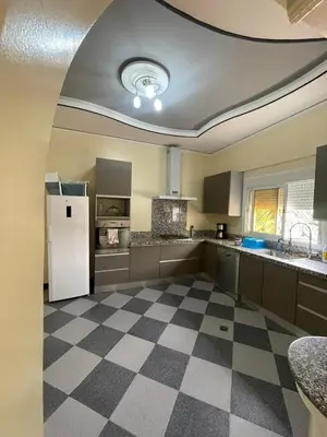 a kitchen with a white refrigerator and a checkered floor at Villa HMR ⵥ in El Ksiba