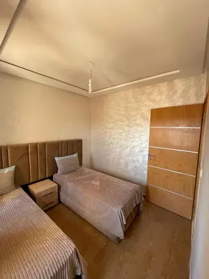 a bedroom with two beds and a dresser at إقامة الرياض الأطلس in Beni Mellal