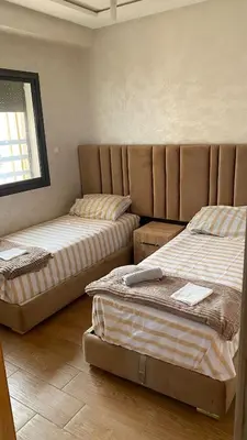 a bedroom with two beds and a window at إقامة الرياض الأطلس in Beni Mellal