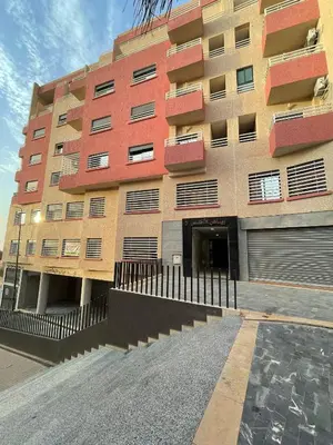 a tallartment building with a parking lot in front of it at إقامة الرياض الأطلس in Beni Mellal
