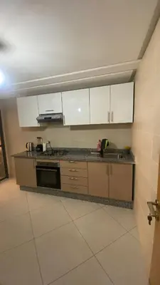 a kitchen with white cabinets and a counter top at إقامة الرياض الأطلس in Beni Mellal