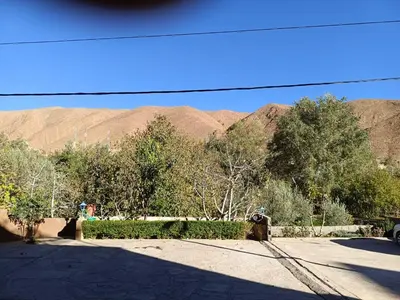a parking lot with trees and mountains in the background at Riad La Belle Vue in Boumalne