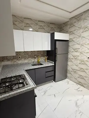 a kitchen with white cabinets and a stove top oven at Kamlia meknes in Meknès