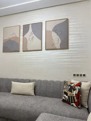 a living room with a couch and four pictures on the wall at Kamlia meknes in Meknès