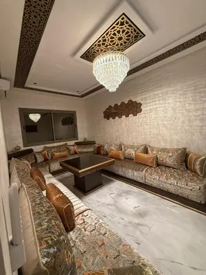 a living room with a couch and a chandelier at Kamlia meknes in Meknès