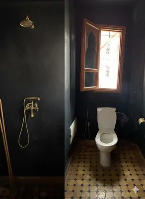 a bathroom with a toilet and a window at Villa d'Exception à Ourika Nichée au Cœur des Montagnes in Aghbalou