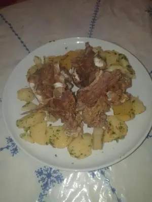 a plate of food with meat and potatoes on a table at Dar lamane in Tamnougalt