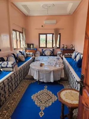a living room with couches and a table at Dar lamane in Tamnougalt