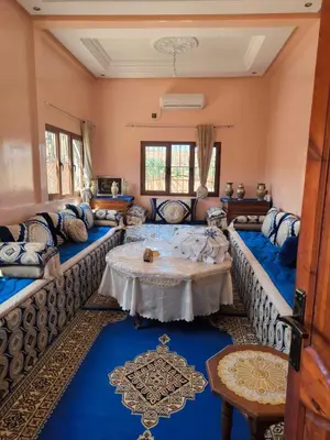 a living room with couches and a table at Dar lamane in Tamnougalt