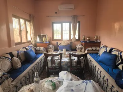 a living room with couches and a table at Dar lamane in Tamnougalt