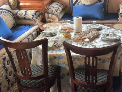 a table with plates of food on it with a couch at Dar lamane in Tamnougalt