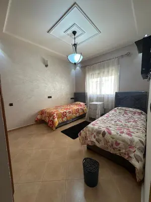 a bedroom with two beds and a window at Mama Zakia Apartment in Fès