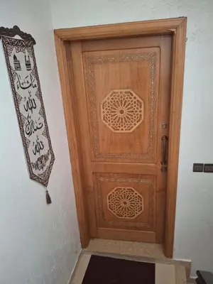 a wooden door with a sign on a wall at Mama Zakia Apartment in Fès