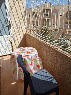a table and a chair sitting on a balcony at Mama Zakia Apartment in Fès