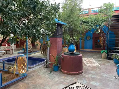 a courtyard with a fountain and trees and a building at Riad Dades Birds Lodge in Boumalne