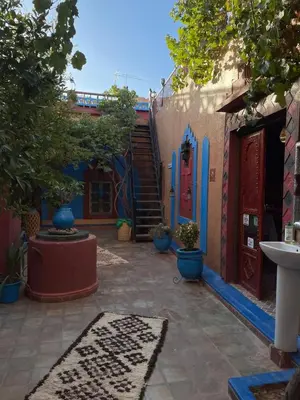 a courtyard with a building with a red door at Riad Dades Birds Lodge in Boumalne